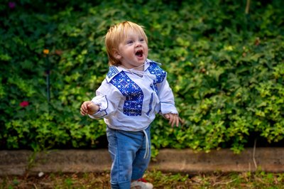 Cibi son in Ukrainian vyshyvanka shirt in the garden — family from Australia